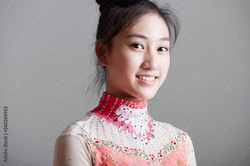Close up of beautiful Asian Chinese female teenager dancer, indoors against white background Close up of beautiful Asian Chinese female teenager dancer, indoors against white background