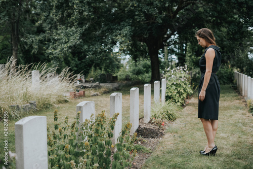 Young widow at a graveyard photo