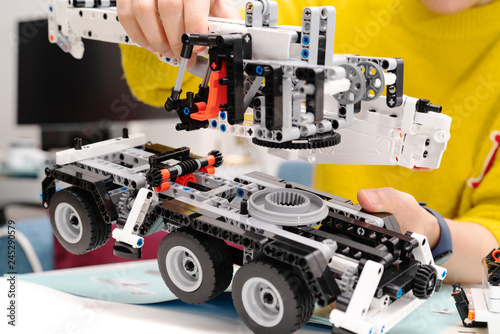 car assembly kit, woman assemble a very complicated and common car truck toy.