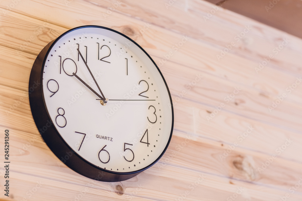 Clock on a wooden wall in the office Clock on a wooden wall in the office