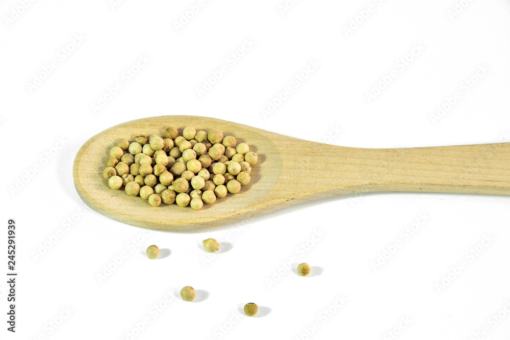 White peppercorns close up, in wooden spoon on a white background isolated White peppercorns close up, in wooden spoon on a white background isolated