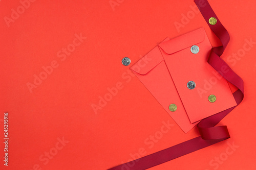 Chinese new year angpao pocket with money inside decorate with red ribbon on red paper background