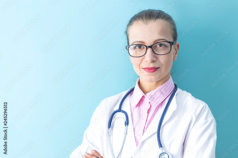Portrait of pretty woman doctor in white coat on blue background. Portrait of pretty woman doctor in white coat on blue background.
