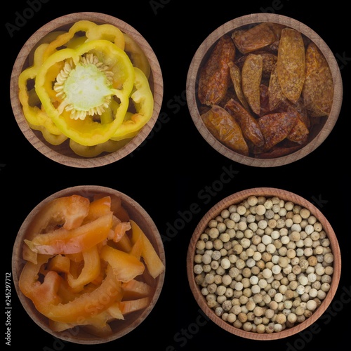 set of peppercorns in wooden cups isolated on black background