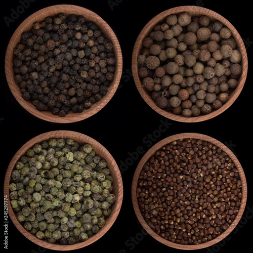 set of peppercorns in wooden cups isolated on black background photo