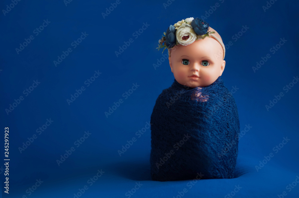 Baby doll toy photodraphed in a newborn style. Vertical posture.