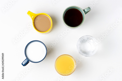 Coffee tea and other drinks in colorful cups on a white background, top view