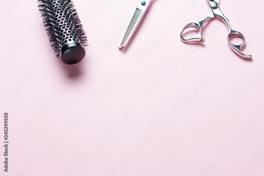 Scissors and comb on a pink background, copy space Scissors and comb on a pink background, copy space