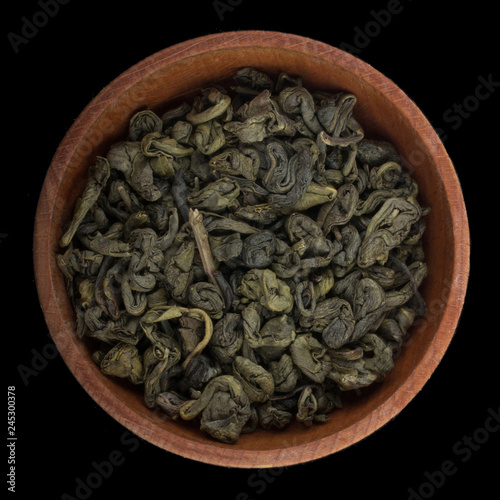green tea in wooden cup isolated on black background. top view