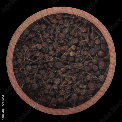 Piper borbonense in wooden cup isolated on black background. top view