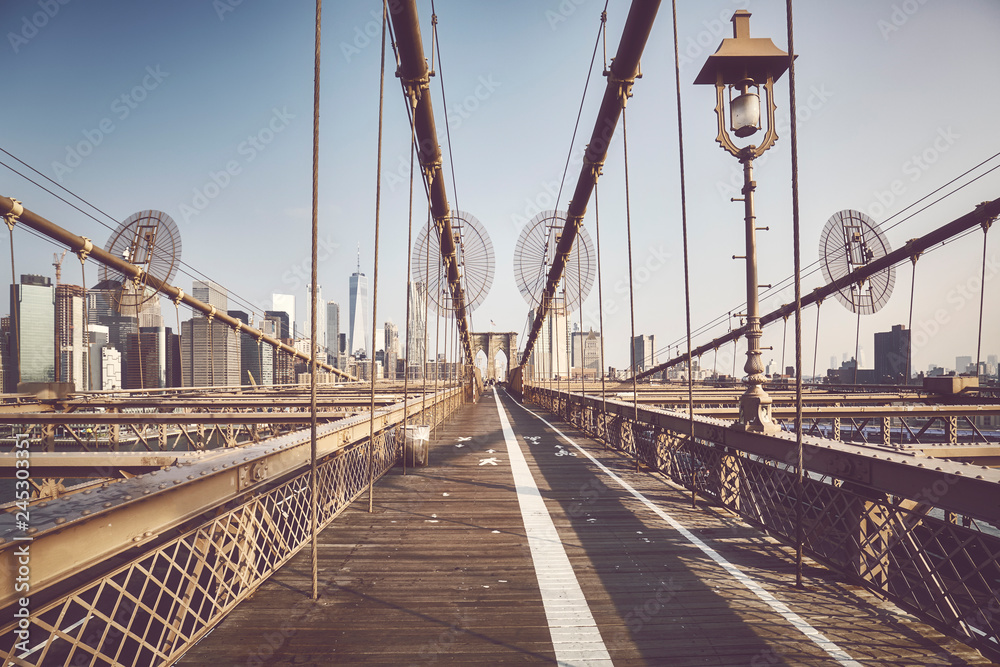 Wide angle view of the Brooklyn Bridge at sunrise, color toned picture, NYC.