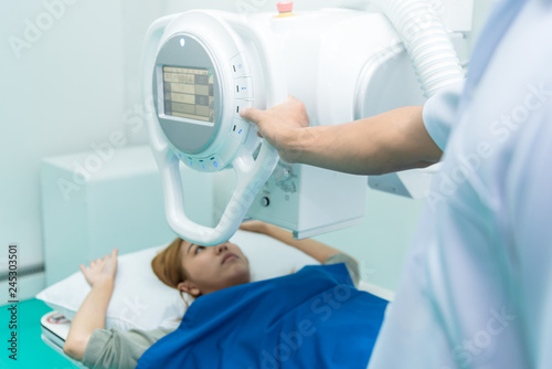 Medicine concept ,Technician Doctor male radiologist with colleague setting up machine to take female patient in x-ray room.Patient in x-ray machine. radiography