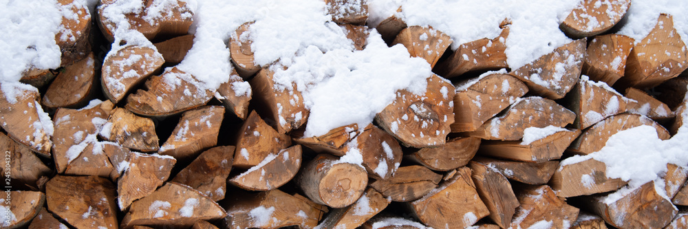 Chopped stock of firewood under snow outdoor