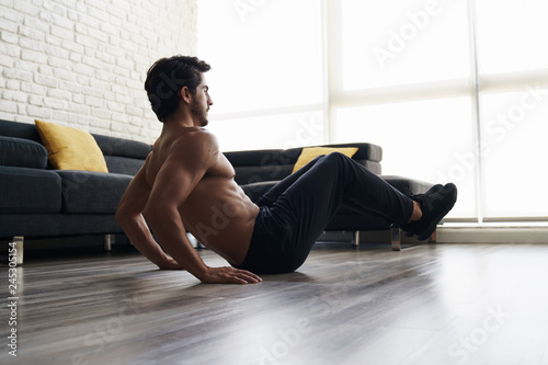 Muscular Attractive Young Man Doing Workout Abs Routine At Home