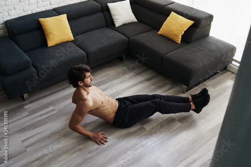 Muscular Attractive Young Man Doing Workout Abs Routine At Home