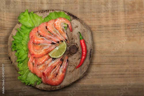 cooked shrims with spices on wooden background photo