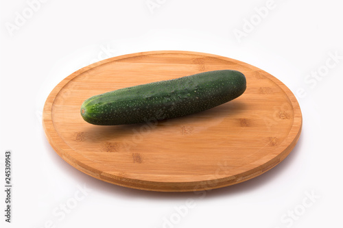 Wooden/Bamboo plate with fresh cucumber on top angle view in white background