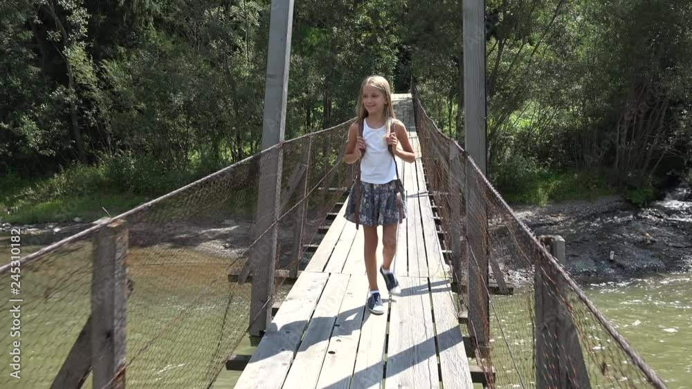 Child on Bridge in Mountains, Kid Hiking in Nature, Girl Looking a River, Stream Child on Bridge in Mountains, Kid Hiking in Nature, Girl Looking a River, Stream