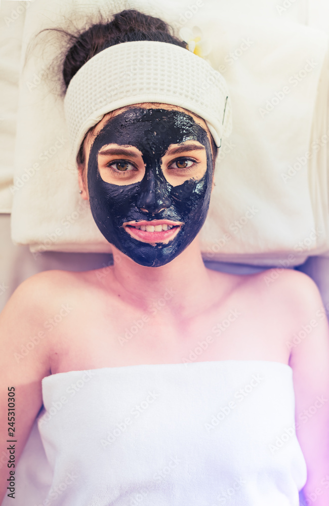 Close up of Healthy Young Woman getting mud Black facial mask cosmetic procedure in the beauty salon.Skin treatment in spa salon concept Close up of Healthy Young Woman getting mud Black facial mask cosmetic procedure in the beauty salon.Skin treatment in spa salon concept