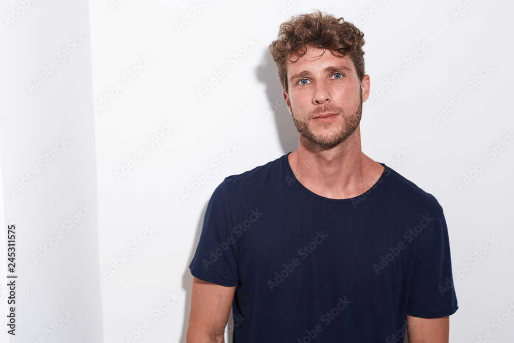 Obraz premium Handsome man in blue t-shirt against white