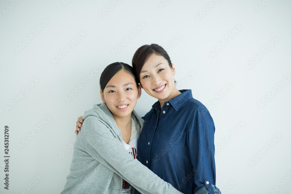 笑顔で寄り添う母親と娘