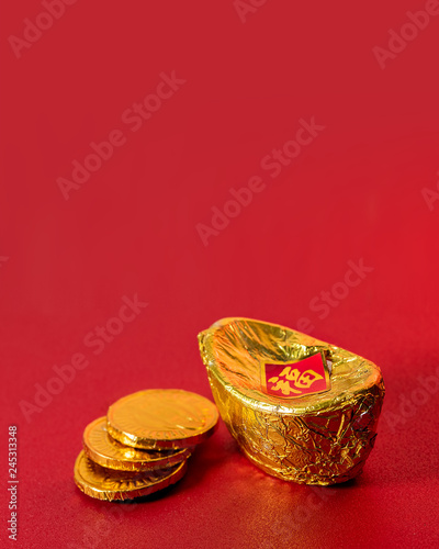 Ancient Chinese Gold Ingot with Three Golden Coins Made From Alumunium Foil on Red Background For Chinese Lunar New Year Greeting and Celebration. Symbol of Wealth and Prosperity