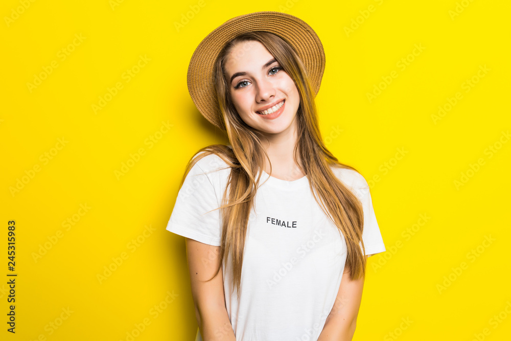 Young woman in straw hat isolated on yellow background Young woman in straw hat isolated on yellow background
