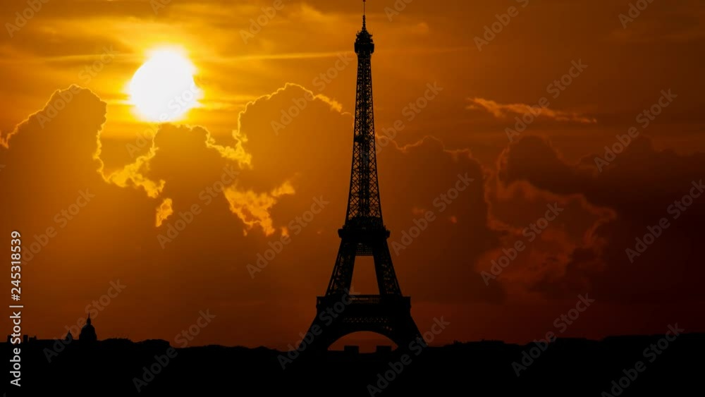 The Eiffel Tower at Sunset in Time Lapse with Sun and Red Clouds. Paris France, Europe