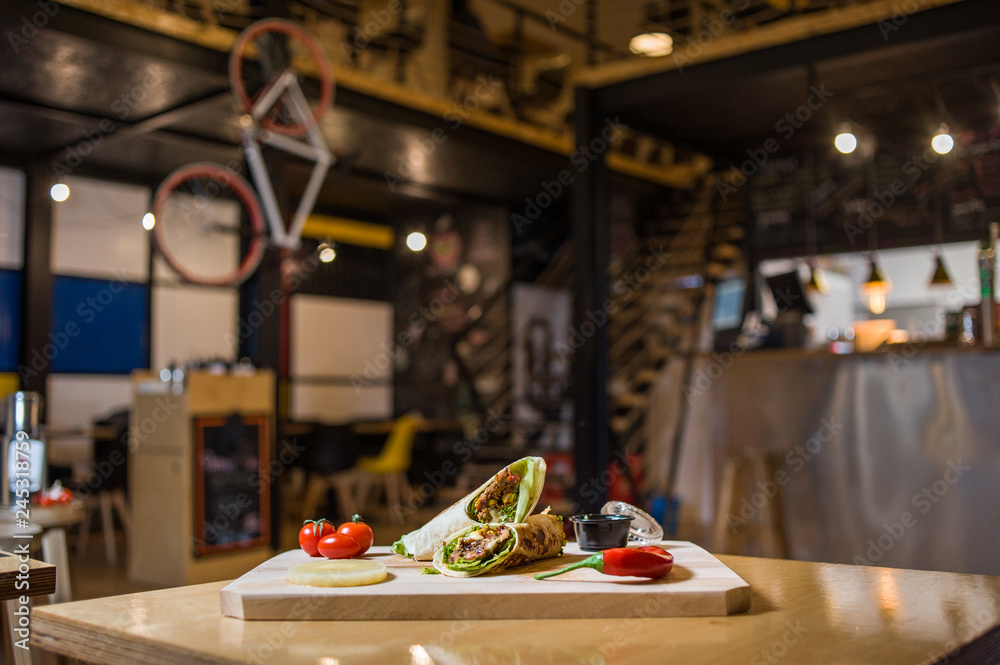 Wrap Sandwich on a wooden board with fresh vegetables.