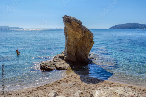 Obraz na płótnie Young woman standing in sea and rock in water, beach in Toulon, Cote d'Azur, France w salonie