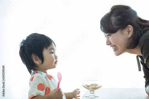 プリンを食べる男の子と見守る母親 photo