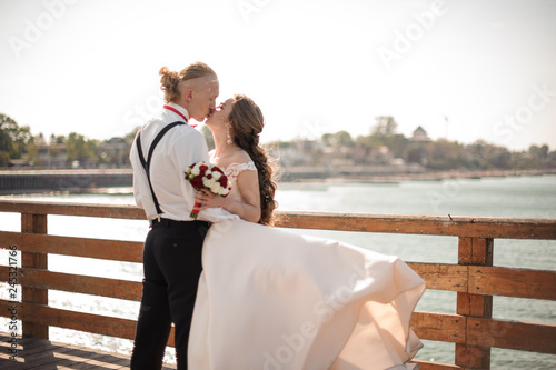 Happy couple kissing on the pier on the lake