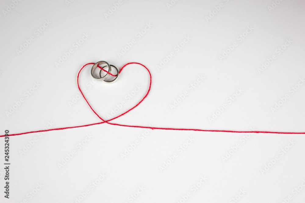 wedding ring joined with heart of thread