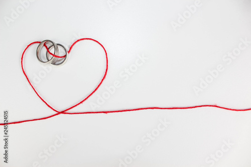 wedding ring joined with heart of thread