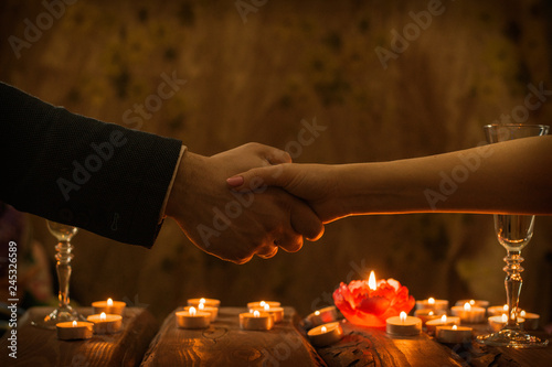 Handshake men and women at dinner by candlelight.