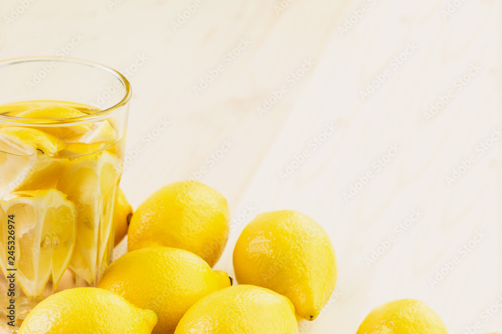 Glass of water with piece of lemon or fresh hand made lemonade Glass of water with piece of lemon or fresh hand made lemonade
