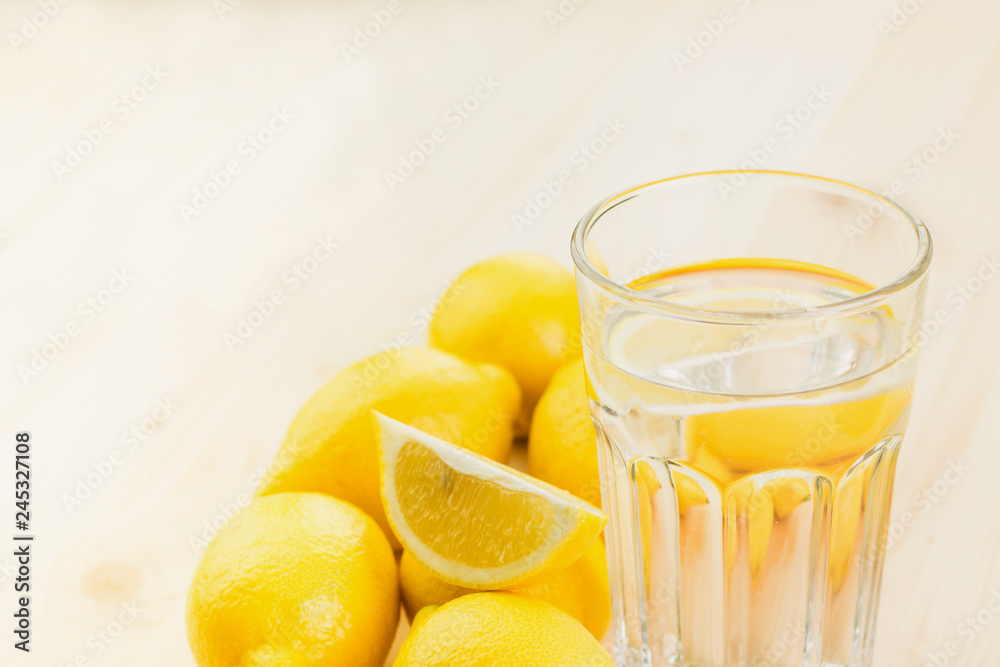 Glass of water with piece of lemon or fresh hand made lemonade