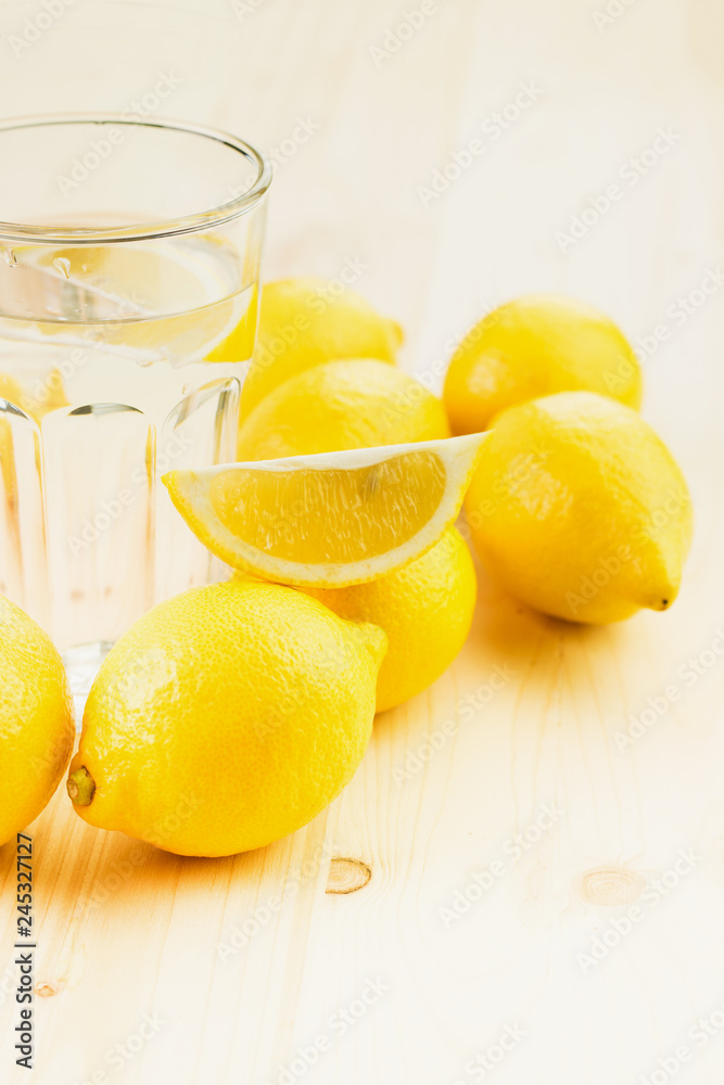 Glass of water with piece of lemon or fresh hand made lemonade Glass of water with piece of lemon or fresh hand made lemonade