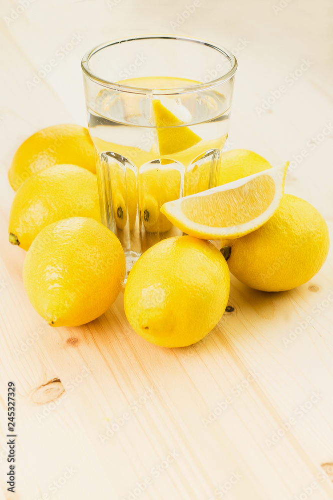 Glass of water with piece of lemon or fresh hand made lemonade Glass of water with piece of lemon or fresh hand made lemonade