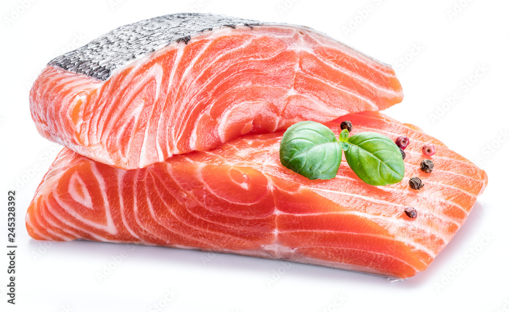 Fresh raw salmon fillets decorated with green basil. Fresh raw salmon fillets decorated with green basil.