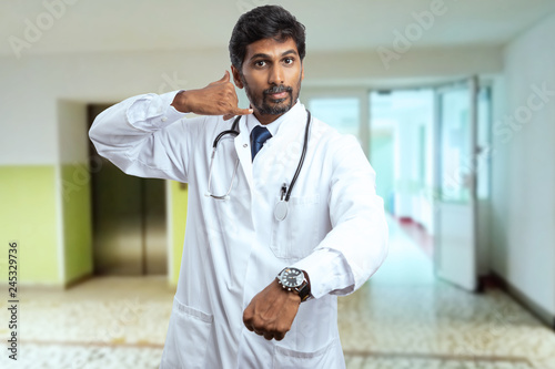 Medic making phone gesture and showing wrist-watch.