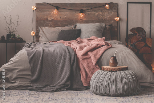 Pastel pink and grey blanket on grey bedding of king size bed in christmas decorated bedroom