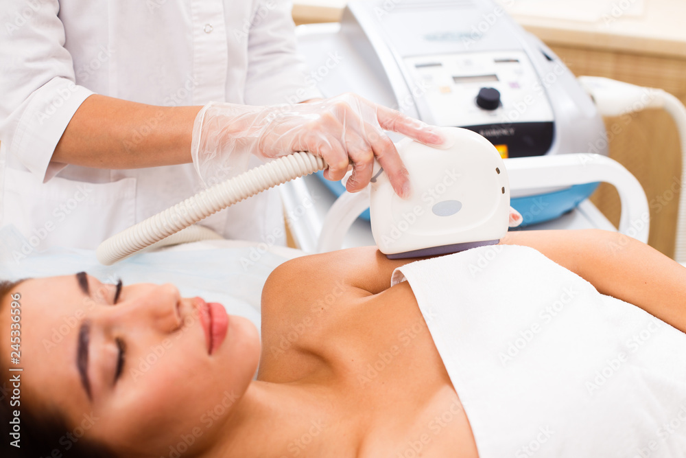 The procedure of photoepilation in the beauty salon. A young woman is removed unwanted hair on her face. Hardware cosmetology. Close up The procedure of photoepilation in the beauty salon. A young woman is removed unwanted hair on her face. Hardware cosmetology. Close up