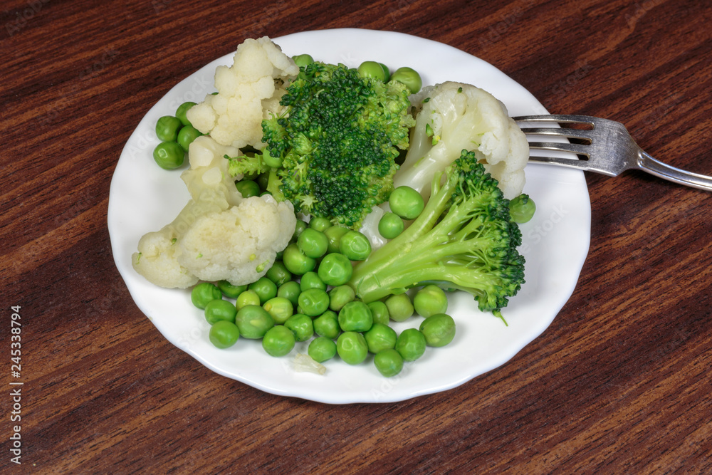 Steamed cauliflower, broccoli and green peas as concept of vegan cuisine. Healthy food lifestyle concept.