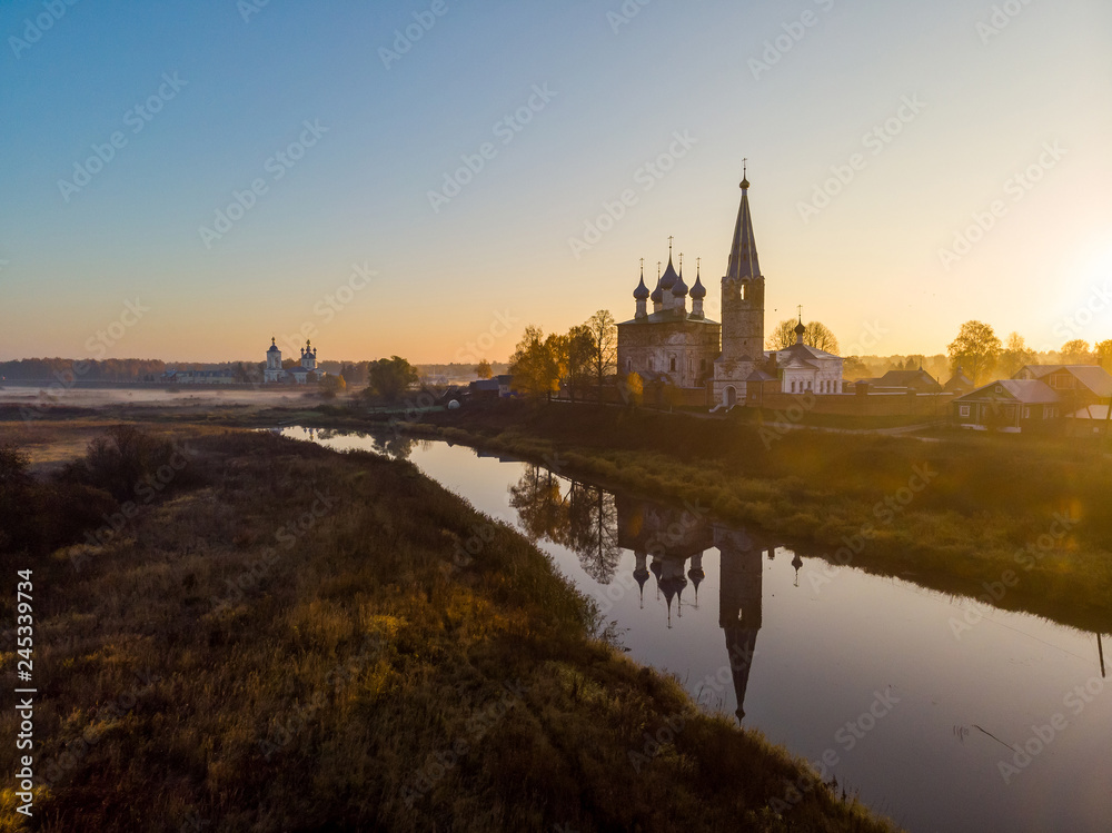 Chruch of the Lady Day in the village of Dunilovo at sunrise reflected in the river