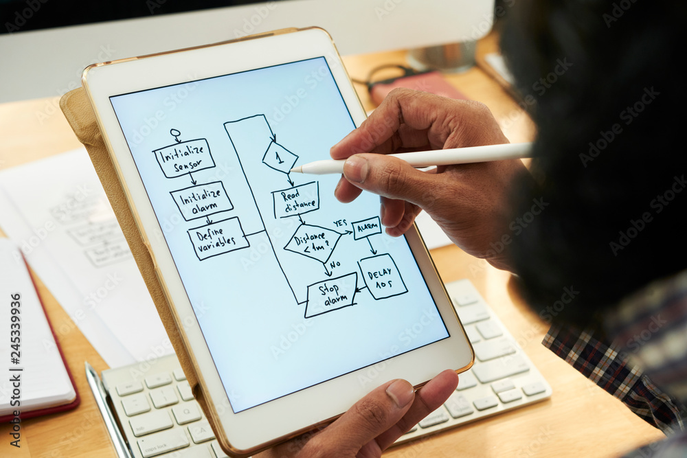 Software developer holding tablet with electronic scheme on display ...