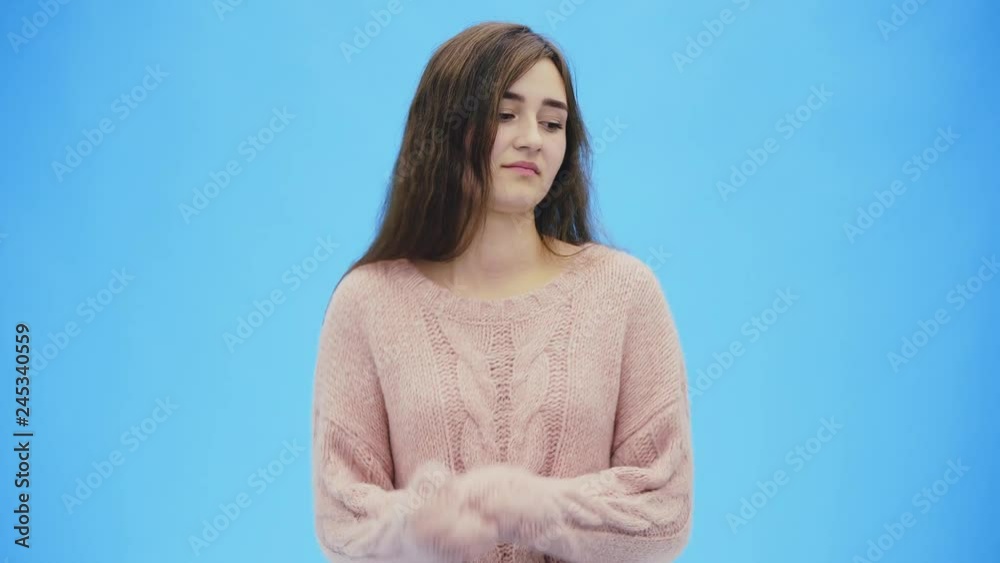 Beautiful young woman with clean, perfect skin. Raises his hands up, pretending to be cold. Beautiful young woman with clean, perfect skin. Raises his hands up, pretending to be cold.