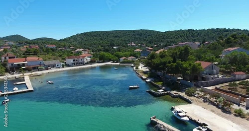 AERIAL - Flight with the DJI Phantom 4 on summer holiday directly at the holiday home over the deep blue Adriatic Sea and part of the village Zdrelac on the island of Pasman in Croatia. photo