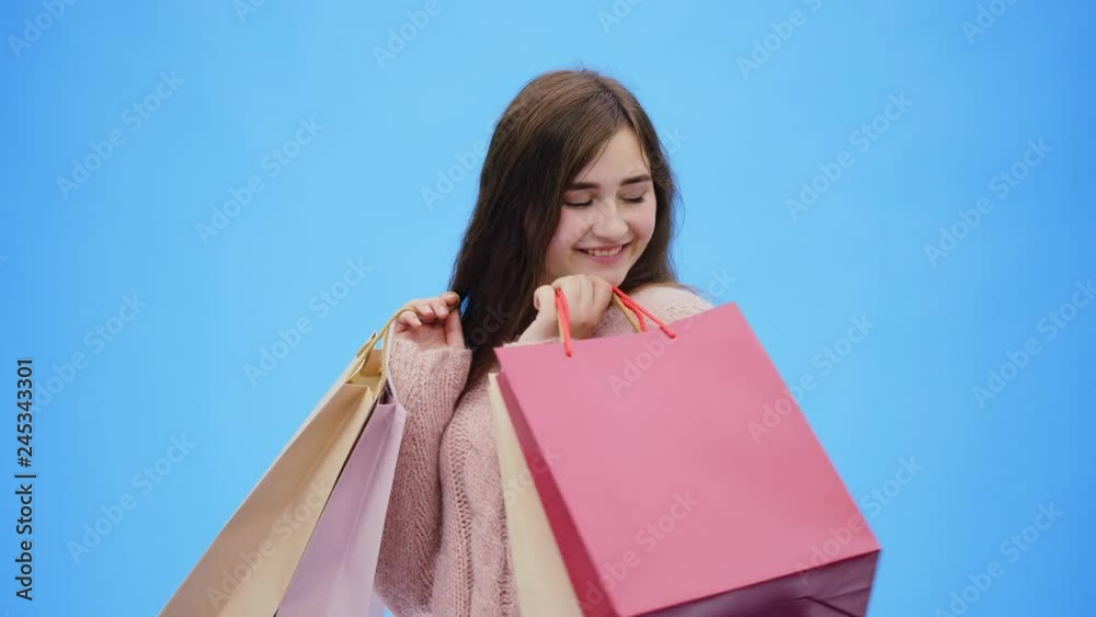 Young pretty girl doing incredibly pleasing shopping. During this she raises her hands and shopping bags up. At the same time, it is incredibly rejoicing.