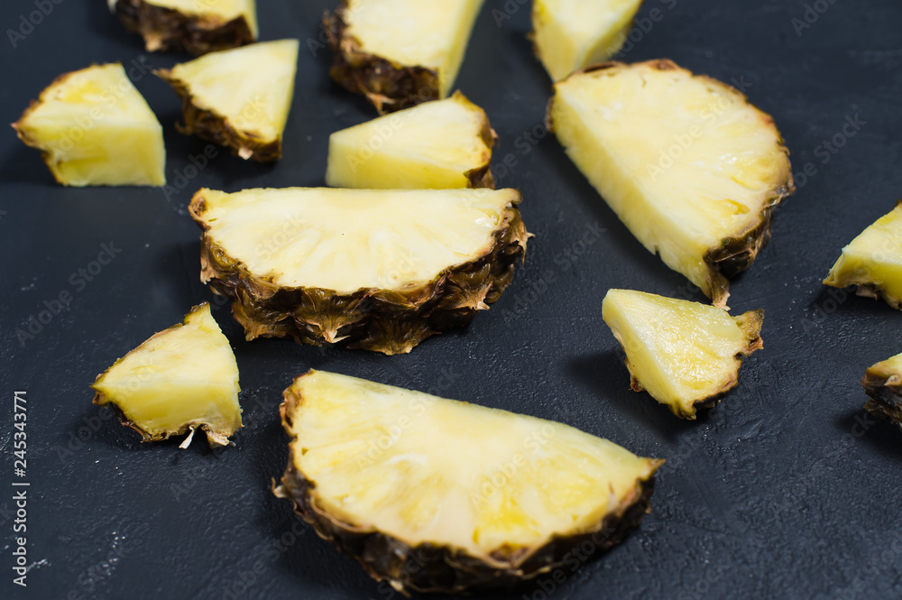 Pineapple slices on a black background, close-up